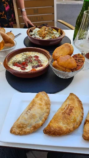 Empanadas y provoletas en una mesa de la terraza